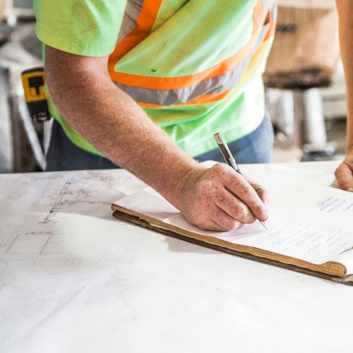 construction worker writing on a clipboard