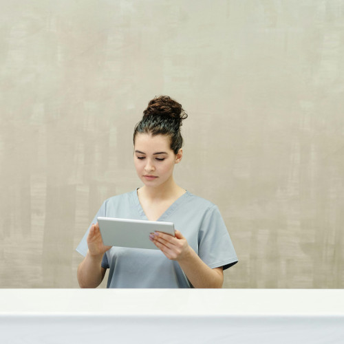 A nurse checking on elderly patients using a tablet