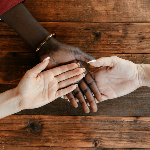 Three hands palms up of different skin tones